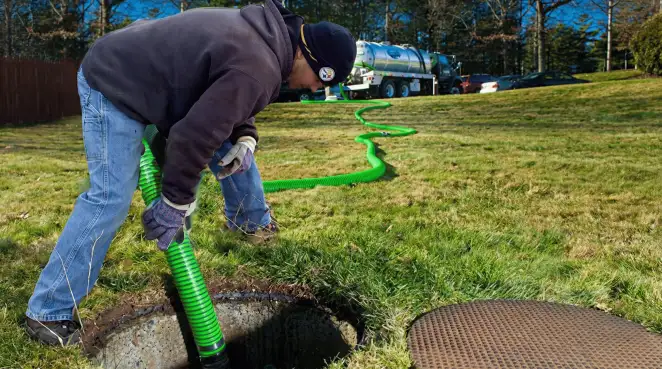 Service technician performing residential septic pumping and drainage maintenance in Boston, MA